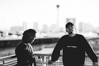 two men standing next to each other on a balcony