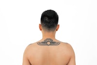 the back of a man with an egyptian tattoo